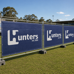 Printed airmesh banner panels cable-tied to temporary event fencing